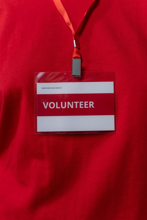 Volunteer identification tag hanging in front of red fabric