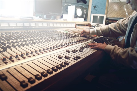 Man using audio mixing desk
