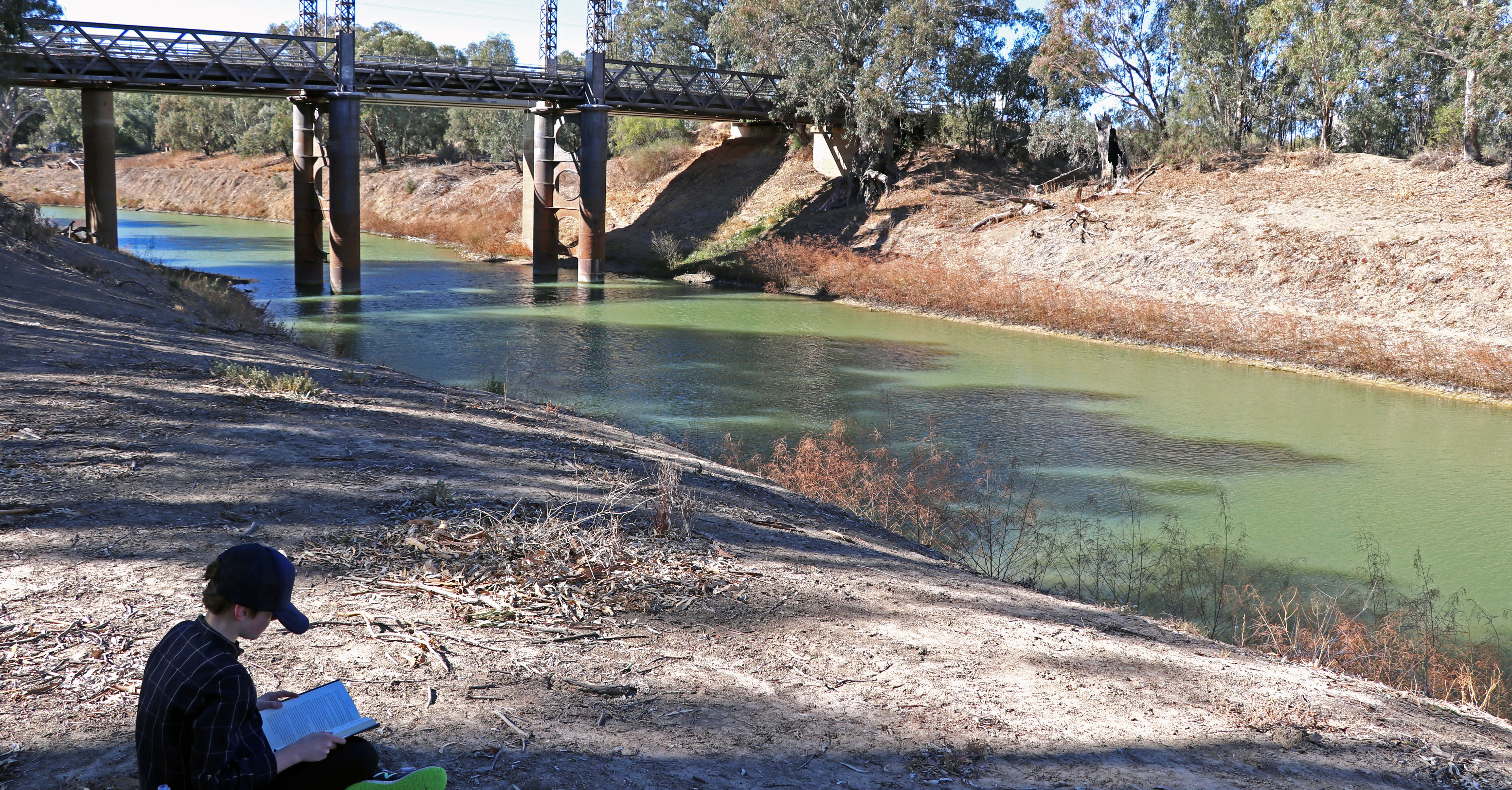 Child reading near Darling River
