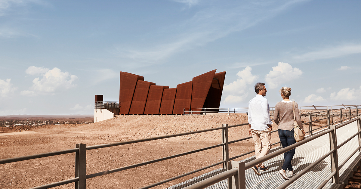 A couple walks towards the Miners' Memorial at Broken Hill