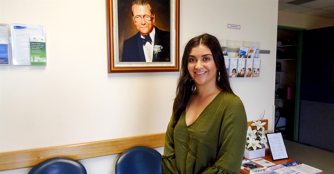 Indiana Shamroze-Tumes poses in front of a portrait