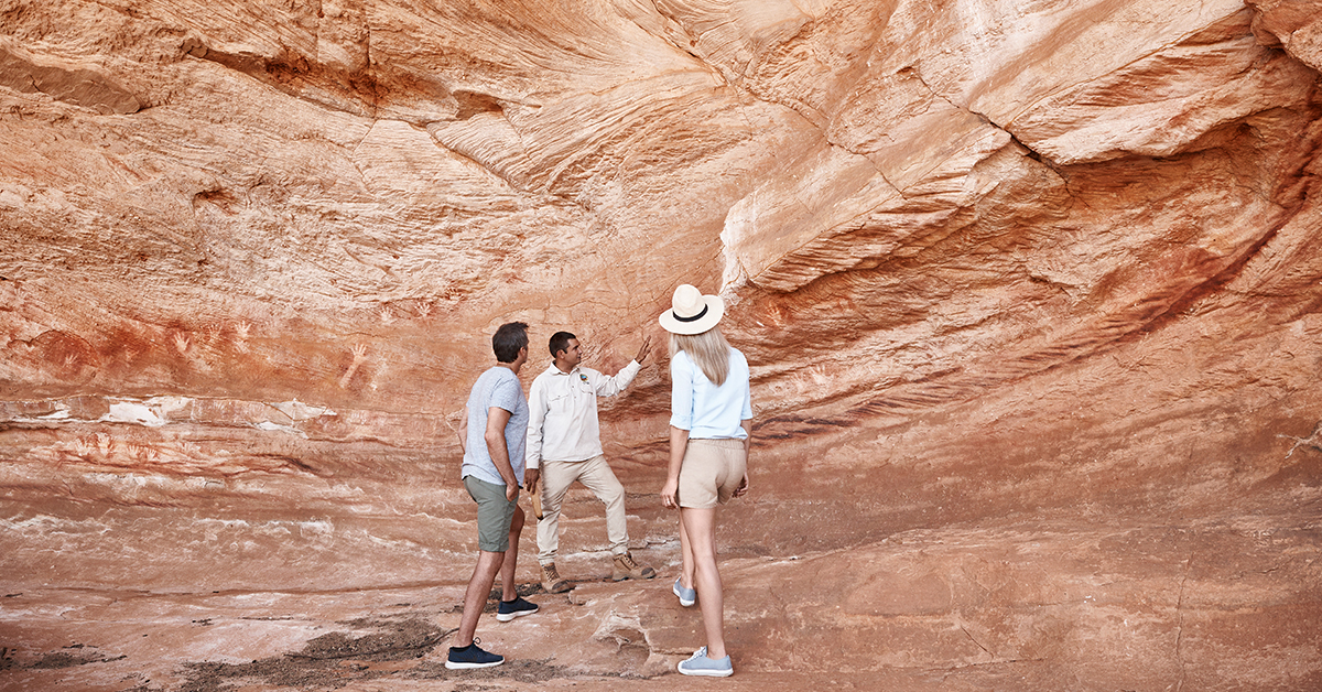 An indigenous guide showing rock art to tourists