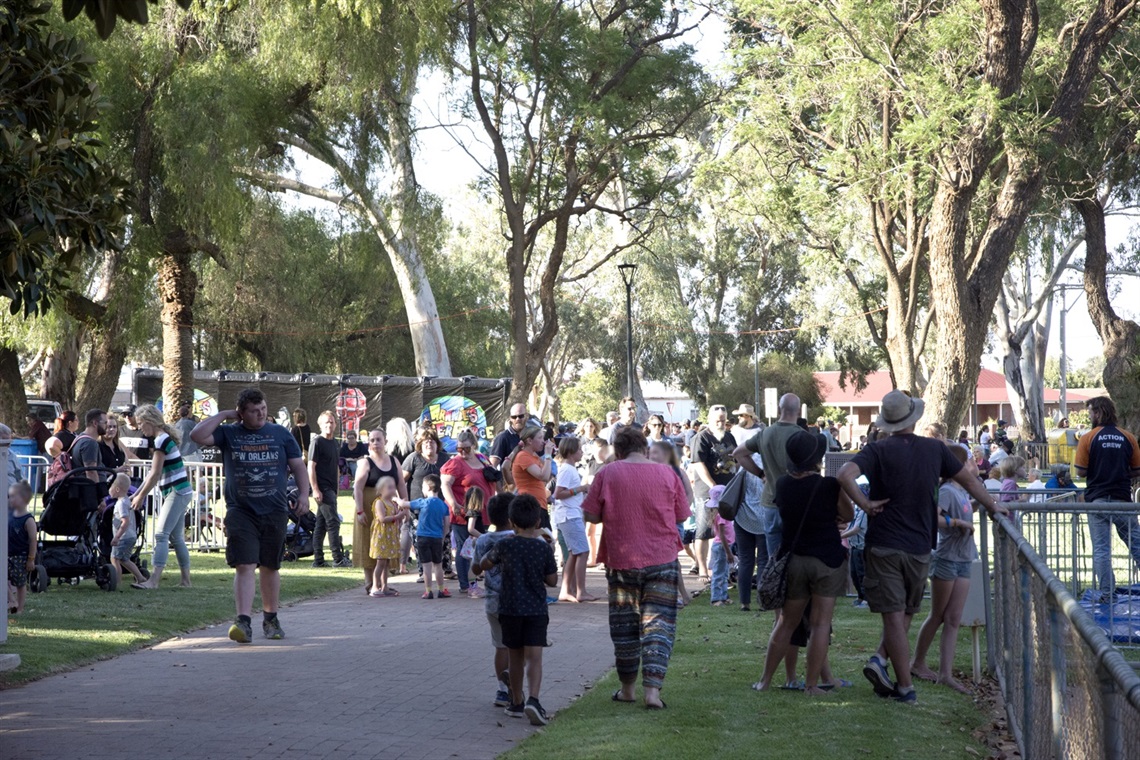 image of a corwd of people gathered and walking through sturt park during a community event