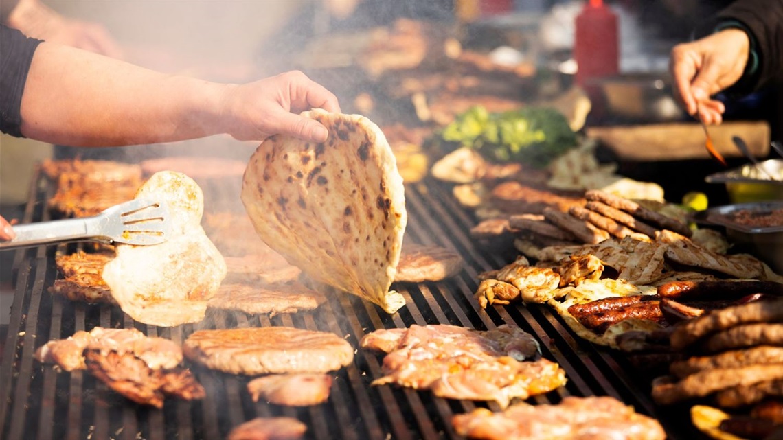 IMAGE OF BARBEUE PLATE, FLATBREAD AND MEATS CAN BE SEEN SMOKING ON THE HOTPLATES.