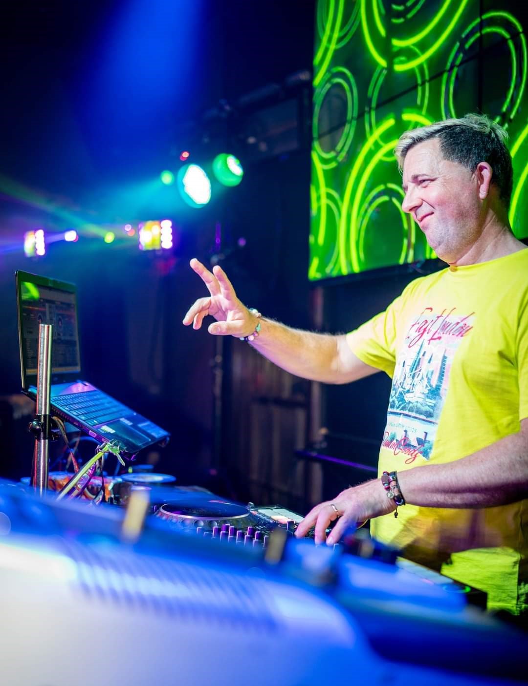 Ash Turner behind his DJ turntables with coloured lighting