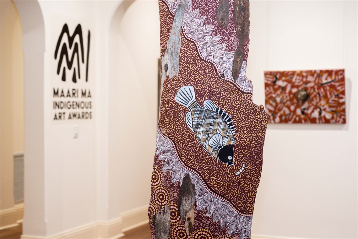 detail of indigenous artwork, with gallery setting out of focus in the background