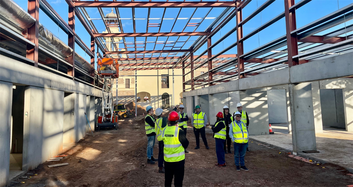 image of council workers, elected officials and tradespeople standing on the site of the library build that is currently underway.