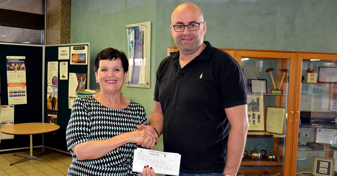 Mayour Turley receives a cheque from the mayor of Canterbury-Bankstown