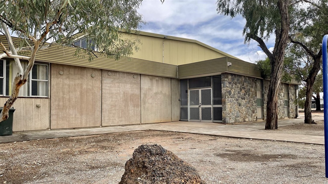 exterior shot of south gymnasium building showing stone walls and a green iron exterior.